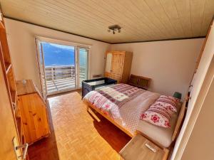 um quarto com uma cama e uma grande janela em Chalet La Louise avec vue imprenable em Crans-Montana