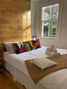 1 cama blanca grande en una habitación con ventana en Interior Designed Flat near Kew Botanical Gardens, en Londres