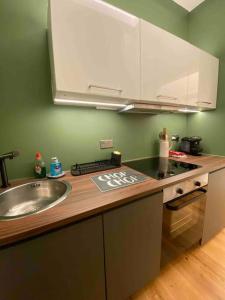 a kitchen with a sink and a counter top at Interior Designed Flat near Kew Botanical Gardens in London