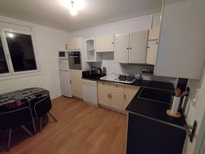 a small kitchen with white cabinets and a table at Appartement Courbaril à Nantes (6) in Nantes