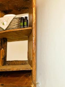 a wooden shelf with bottles on it next to a wall at Errika's Sweet Home in Provatas