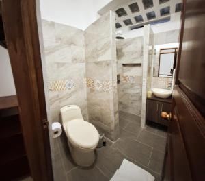 a bathroom with a toilet and a sink at Volarte Hotel in Jardin