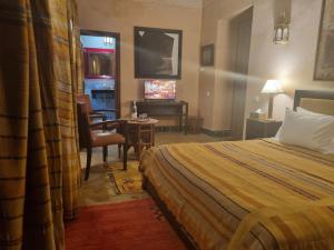 um quarto de hotel com uma cama e uma secretária em Riyad Al Moussika em Marrakech