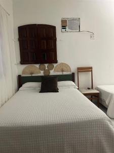 a bedroom with a large bed with a large headboard at ACM Flat in Natal