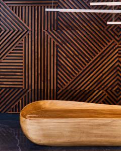 Pullman Lima Miraflores في ليما: مقعد خشبي في غرفة بجدار خشبي