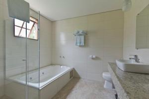 a bathroom with a tub and a toilet and a sink at Resort Fazenda 3 Pinheiros in Engenheiro Passos