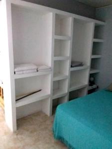 a white closet with white shelves and a bed at LUPITA CENTRO 1 in General Roca