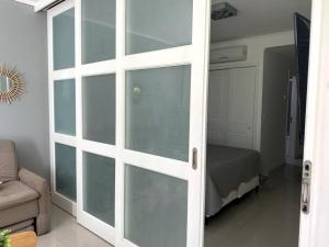 uma porta de vidro deslizante numa sala de estar com uma cama em Depto PB con Jardín - Green Park em Punta del Este