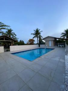 a swimming pool with blue water on a tile floor at loft 2 sitio do barrigudinho in Saquarema