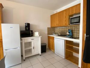 a kitchen with wooden cabinets and a white refrigerator at Appartement Valloire, 2 pièces, 4 personnes - FR-1-263-421 in Valloire
