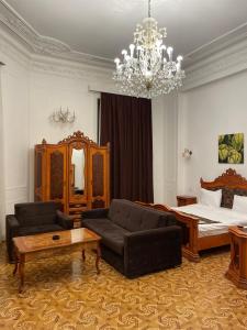un soggiorno con letto e lampadario pendente di Malakan Boutique Nizami Hotel a Baku