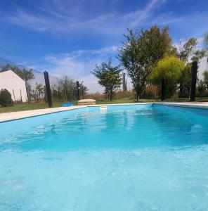 una gran piscina de agua azul en Casa de campo en Zapiola , Lobos, Buenos Aires. en Lobos