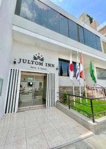 a building with flags in front of it at Jultom Inn Hotel & Suites in Trujillo
