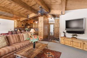 a living room with a couch and a flat screen tv at Shadow Mountain 14 in Aspen