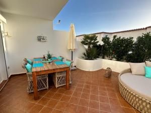 a patio with a table and chairs and a couch at Casa BLANKA Bahia Playa Anlage Costa Calma in Costa Calma