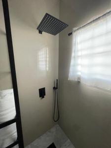 y baño con ducha y ventana. en El Balcón de Luly, en Culebra