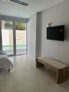 a bedroom with a bed and a flat screen tv on the wall at DELAMAR Casa de playa in Coveñas