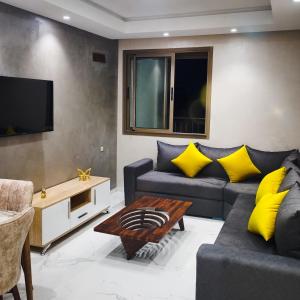uma sala de estar com um sofá e uma televisão em Super Apartement Totalement neuf a Marjane M2 em Tânger