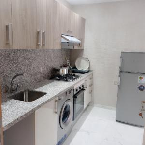 eine kleine Küche mit Spüle und Kühlschrank in der Unterkunft Super Apartement Totalement neuf a Marjane M2 in Tangier
