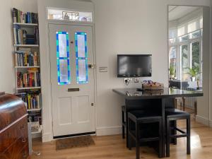 a room with a desk and a door with a window at Interior Designed Flat near Kew Botanical Gardens in London