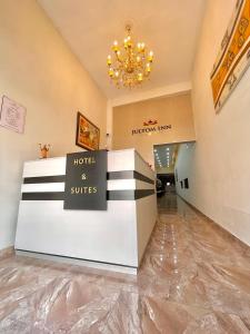 un hotel y suites vestíbulo con una lámpara de araña en Jultom Inn Hotel & Suites, en Trujillo