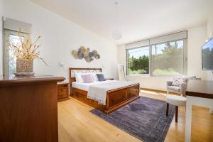 Schlafzimmer mit einem Bett, einem Schreibtisch und einem Fenster in der Unterkunft Phillyrėa Luxury Villas in Kos-Stadt