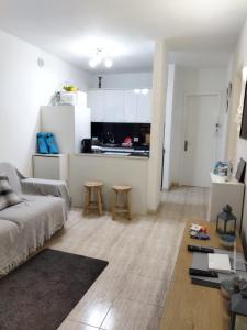 een woonkamer met een bank en een keuken bij Casa alisios 71 in Corralejo