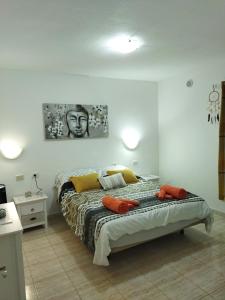 een slaapkamer met een bed en een schilderij aan de muur bij Casa alisios 71 in Corralejo