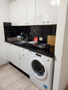 een keuken met een wasmachine en een wastafel bij Casa alisios 71 in Corralejo