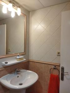 een badkamer met een wastafel en een spiegel bij Casa alisios 71 in Corralejo