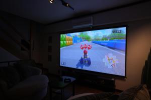 Cinema Resorts 3 في موتوبو: تلفزيون مع ألعاب فيديو عليه في غرفة المعيشة