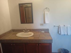 a bathroom with a sink and a mirror and towels at Hostal San Jose in San José del Cabo