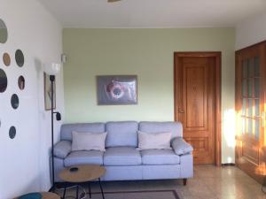 uma sala de estar com um sofá azul e uma mesa em AIRE - centro Palafrugell - Solo adultos - mascotas sí em Palafrugell
