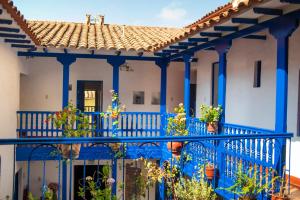 a blue balcony with potted plants on it at Rumi Wasi in Cusco