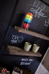 a shelf with coffee cups and a chalk board at Bologna Travel Suite in Bologna