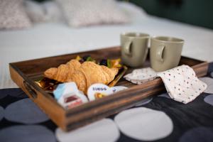a tray of food on a table with two cups at Bologna Travel Suite in Bologna
