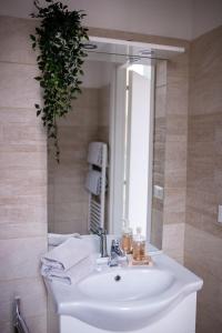 a bathroom sink with a mirror and a plant at Bologna Travel Suite in Bologna