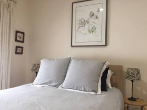 a bed with two pillows and a picture on the wall at Goodwood 3BR Close to City! in Wayville