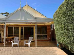 a house with two white chairs and a table at Goodwood 3BR Close to City! in Wayville