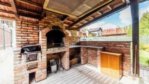a patio with an outdoor kitchen with a brick oven at Chalupa u Havranov in Bystrá