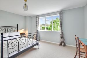 a bedroom with a bed and a window at Stonemason's Cottage in South Cerney