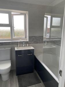 a bathroom with a toilet and a sink and a shower at Binks Bungalow in New Hunstanton