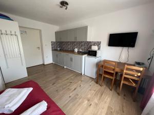 eine kleine Küche mit einem Tisch und einem TV in einem Zimmer in der Unterkunft Villa Angel'OK in Hévíz