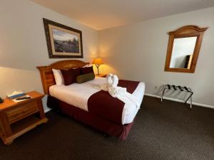 ein Schlafzimmer mit einem Bett mit einem ausgestopften Tier darauf in der Unterkunft Alpine Motel in Jackson