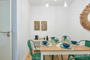 una sala da pranzo con tavolo e sedie verdi di Inglesinhos - Castelo a Lisbona