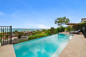 a swimming pool with a view of the ocean at Phuza Maningi 17 Myan Close in Corlette