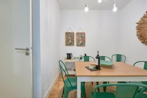 una sala da pranzo con tavolo e sedie verdi di Inglesinhos - Castelo a Lisbona