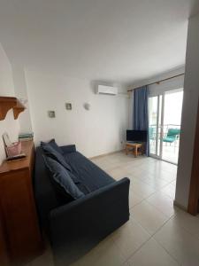 a living room with a couch and a table at Apartamento con piscina en el centro de Blanes in Blanes