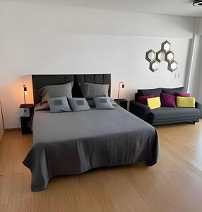 a bedroom with a large bed and a couch at Studio Moderno Amoblado en Puerto Madero in Buenos Aires