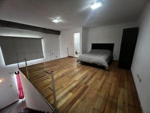 a bedroom with a bed and a wooden floor at ITALIA 1 in Villa María